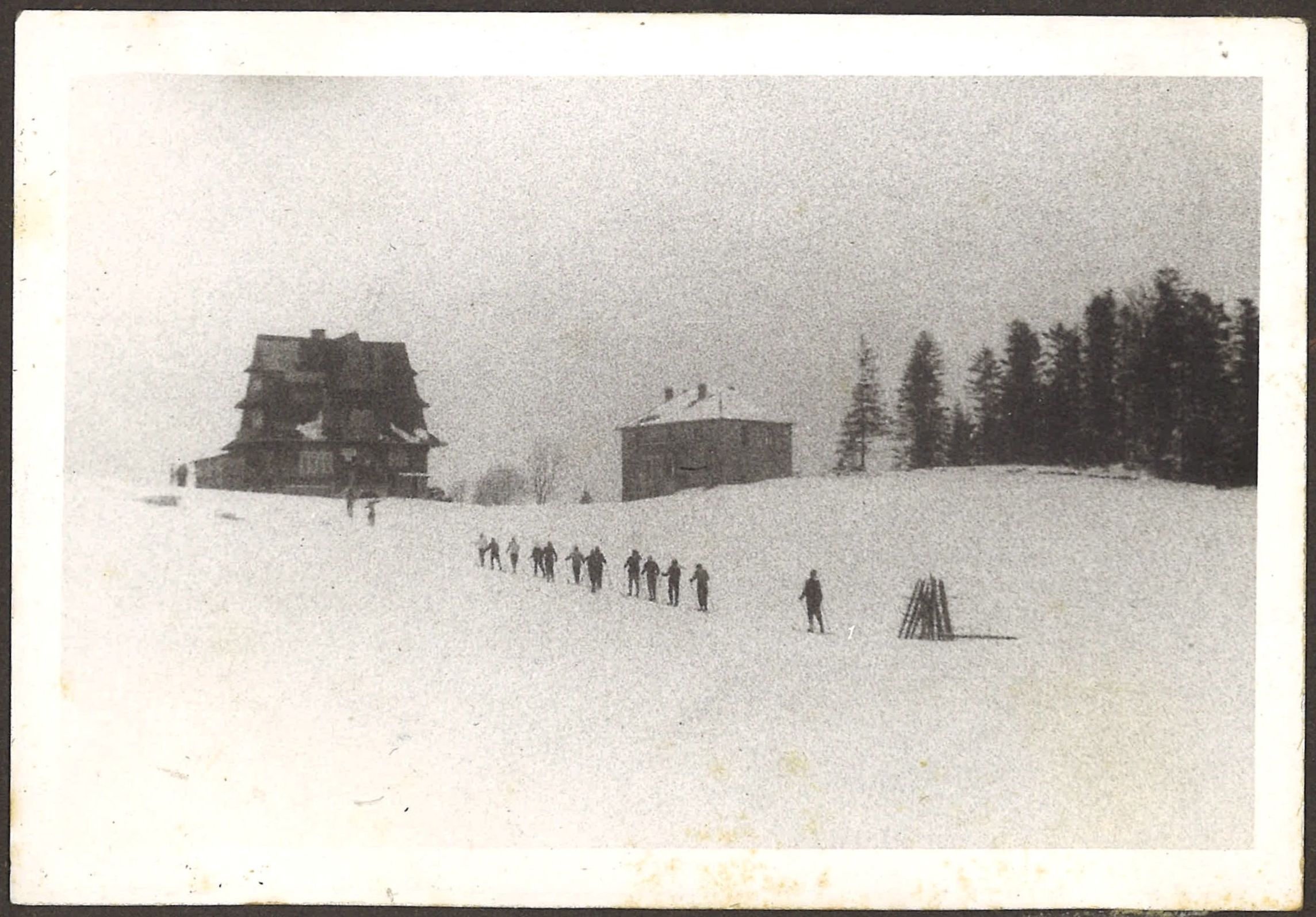 Korowód ludzi zdążających po śniegu do górskiego schroniska (oszac. 1937)